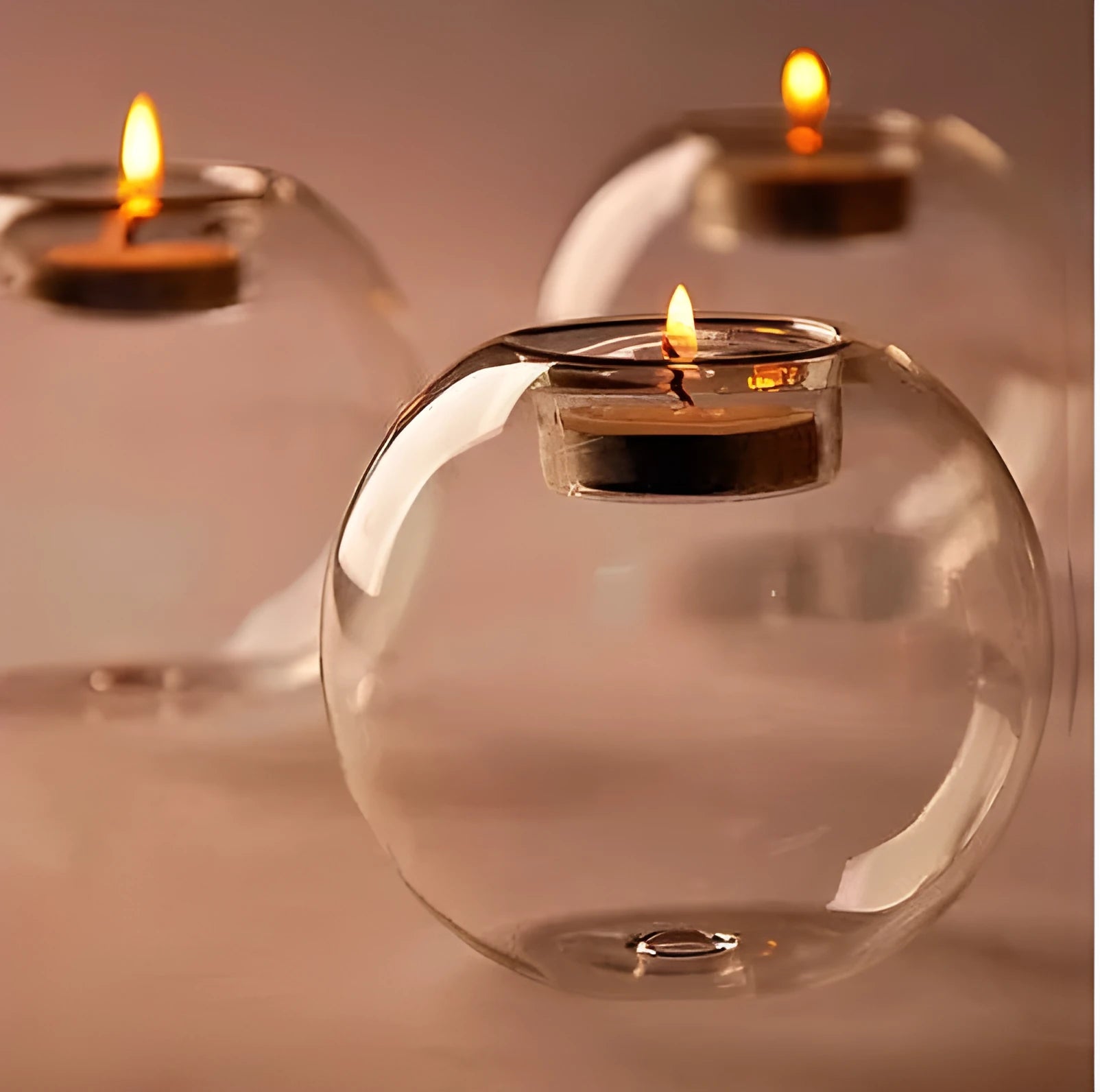 Clear handmade round hollow glass candleholder on a table.