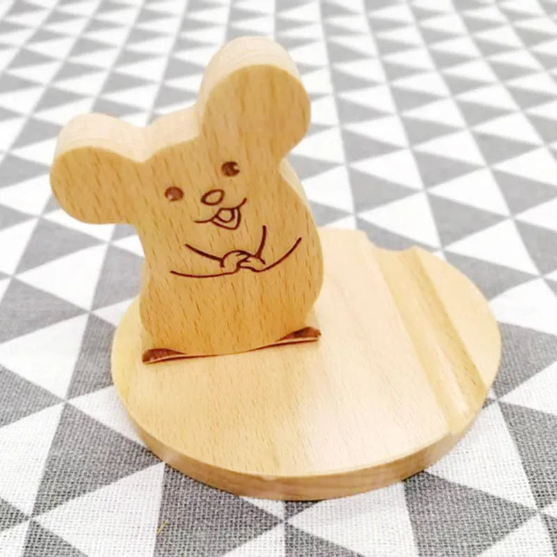 Beech wood and resin mobile phone holder with decorative animal design on desk