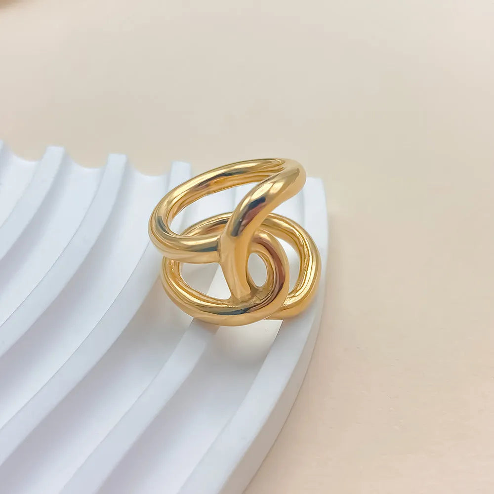 Women's stainless steel geometric ring with a knotted detail and adjustable opening in gold or steel colour.