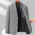 A man wearing a simple, solid-colour loose-fit suit coat for spring or autumn.