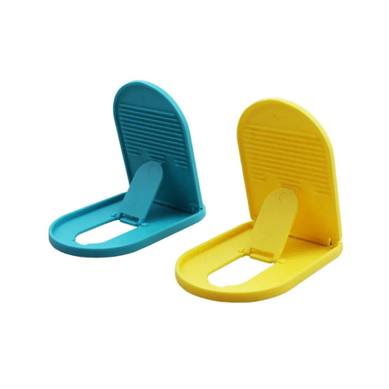 A plastic lazy bracket mobile phone stand on a table, shown in one of six available colours.