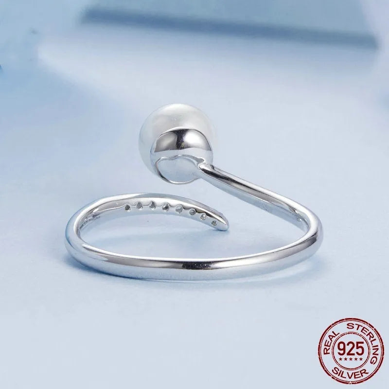Women's adjustable sterling silver ring with a natural shell pearl on an opening loop band.