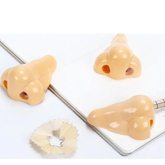 Flesh colour plastic student pencil sharpener with large nostril hole showing geometry shape