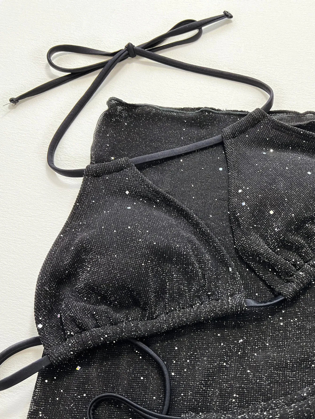 Black women's three-piece bikini swimsuit set consisting of a top and shorts on a mannequin.