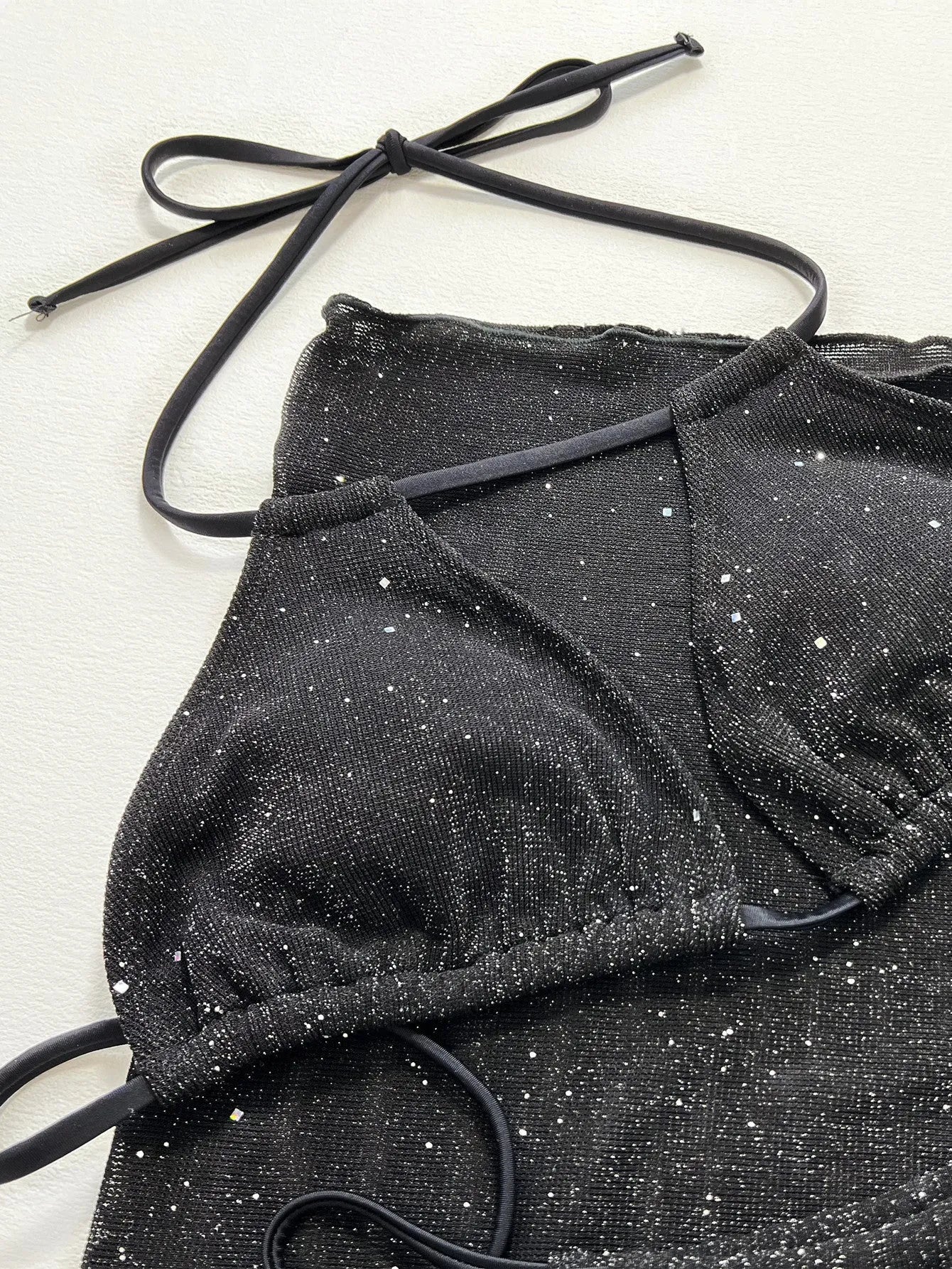 Black women's three-piece bikini swimsuit set consisting of a top and shorts on a mannequin.