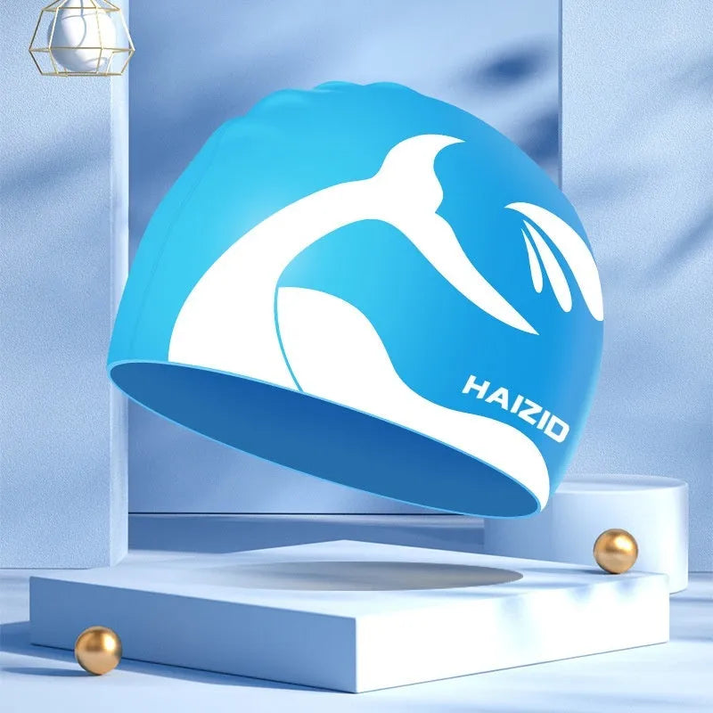 Silicone swimming cap with raised whale tail pattern and integrated ear protectors in multiple colour options