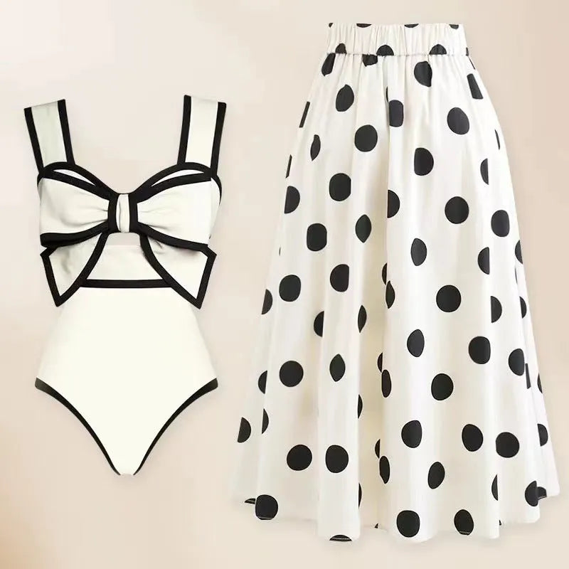 Women's black one-piece swimsuit with a white round skirt and bow detail on the front.
