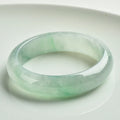 Light green jade bracelet with smooth surface showing natural stone texture