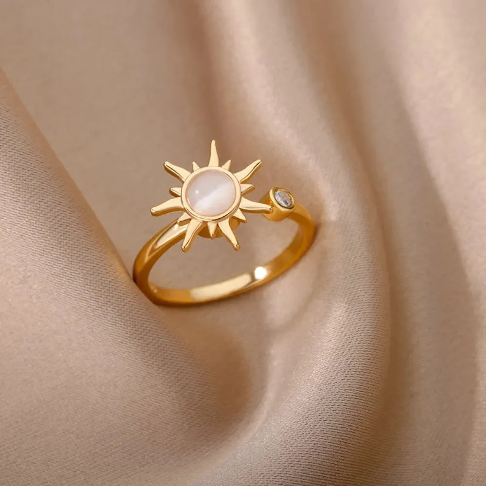 Gold and platinum coloured adjustable geometric decompression ring with rotatable element on a white background.
