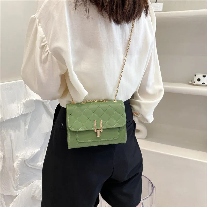 Women's diamond lattice chain crossbody bag in black, white, or green with adjustable strap