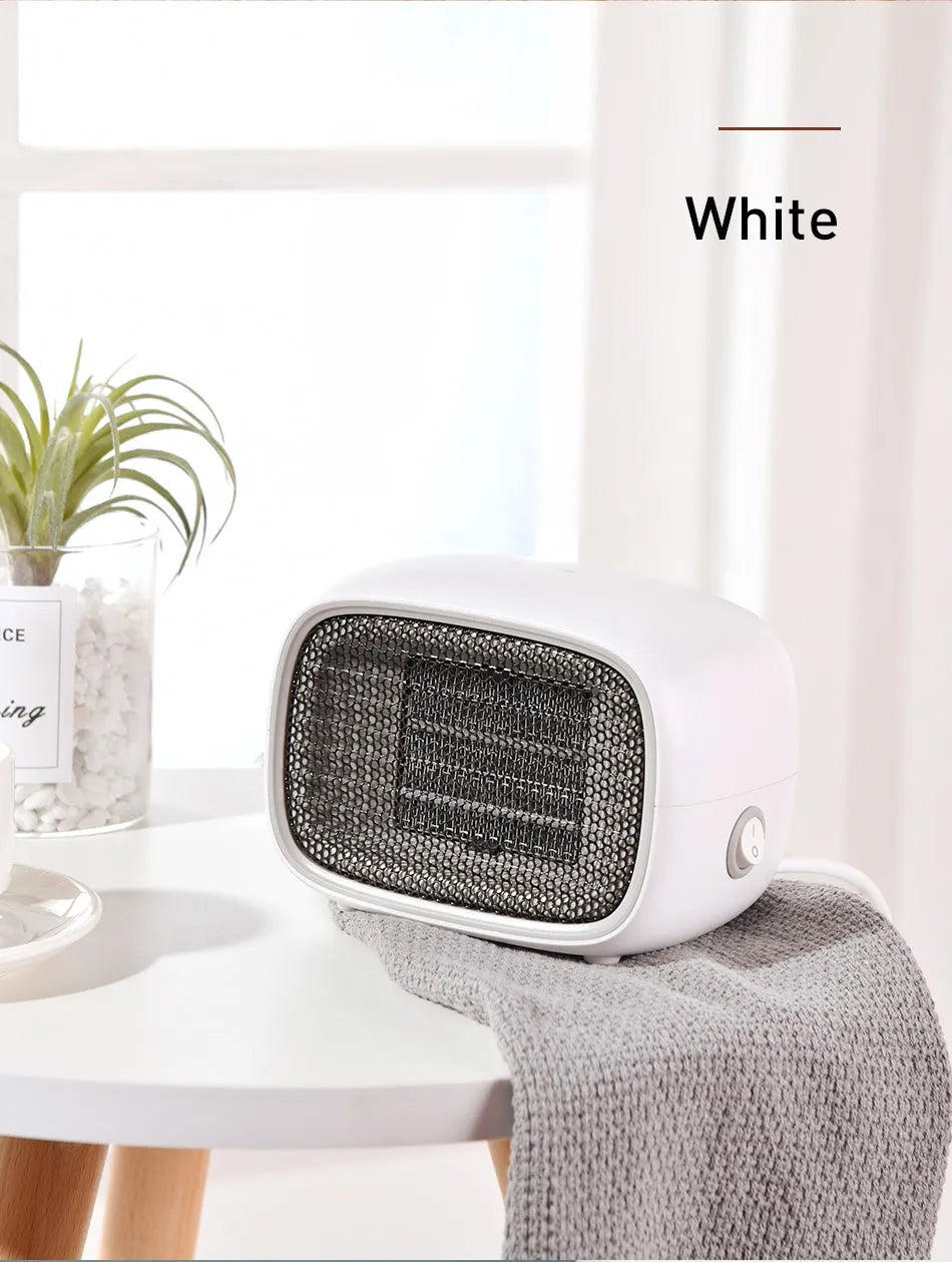 Compact green mini ceramic heater with metal mesh grille on a desk
