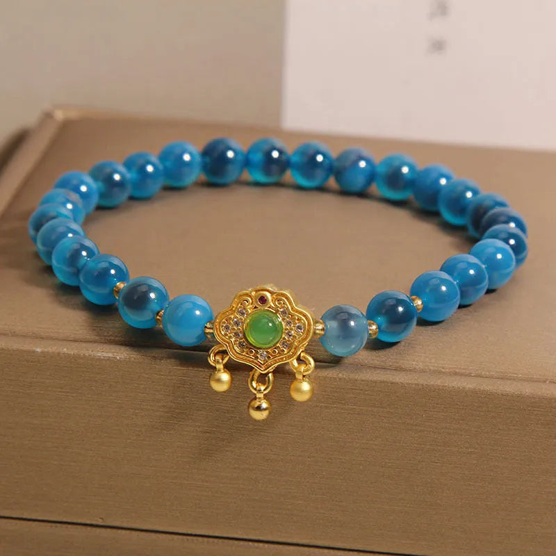 Blue sugar heart agate and jade safety lock pendant on a women's crystal bracelet with alloy inlay.