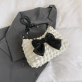 Women's black canvas one-shoulder handbag with a horizontal square shape and single strap