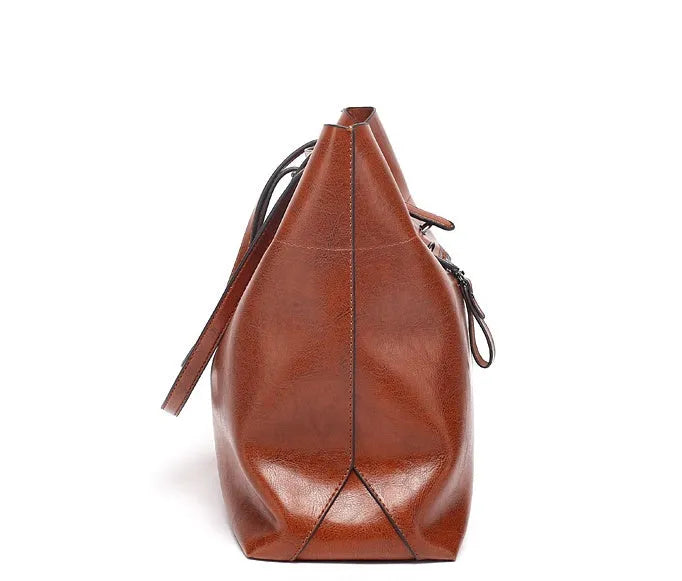 Brown leather crossbody handbag showing two main compartments and a front phone pouch