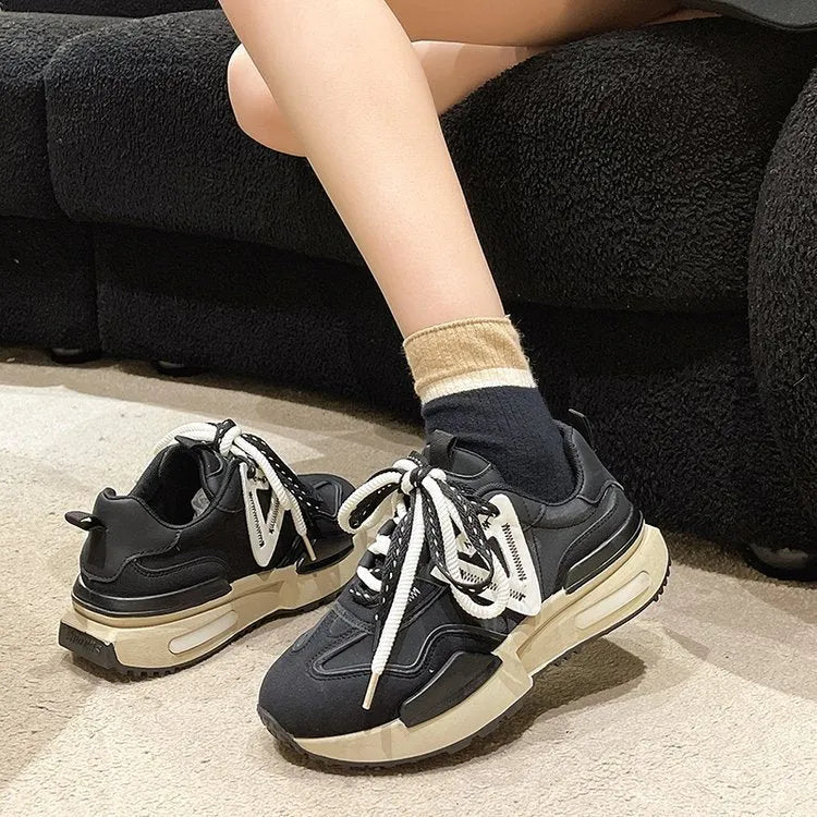 Women's black retro platform sports shoes with round toe and lace-up fastening on a neutral background.