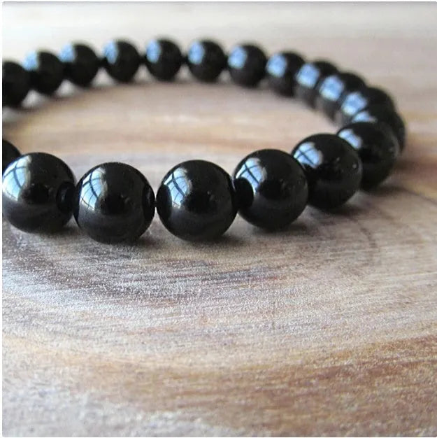 Women's black onyx bead bracelet with geometric design on a stretchy elastic cord.