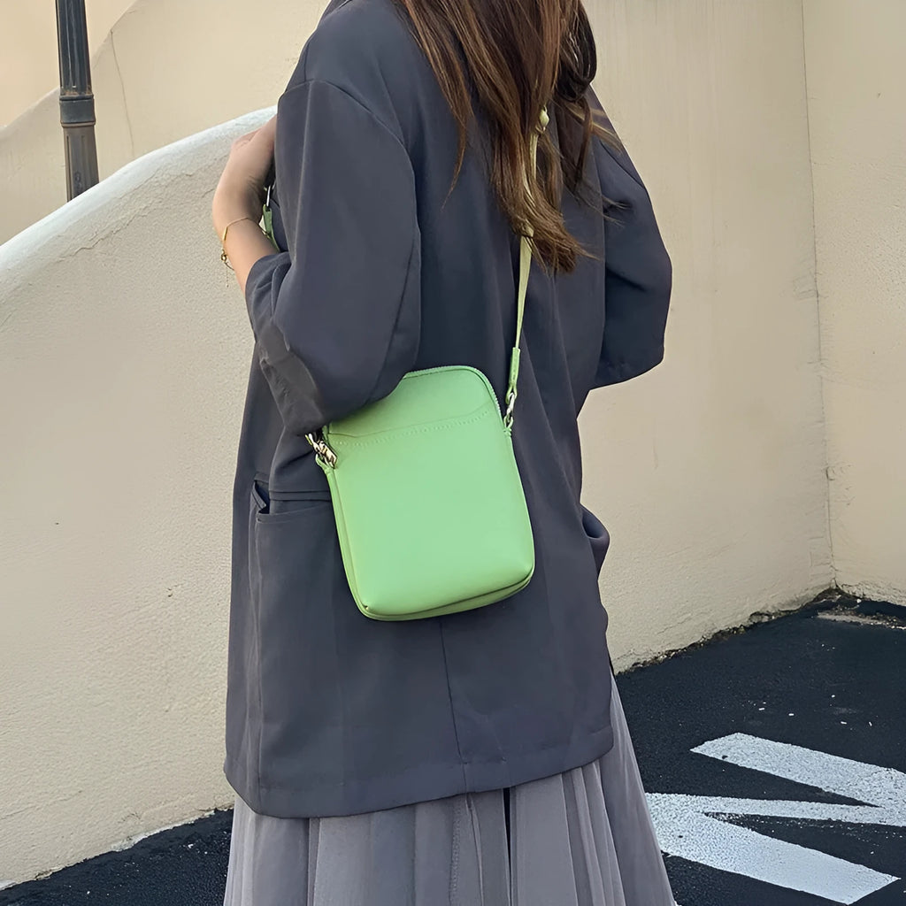 Black PU mobile phone bag with crossbody strap showing shoulder carry option