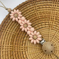 Silicone flower-shaped pacifier clip in Baby Pink with small beads and metal clip mechanism
