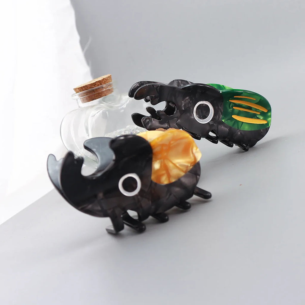 Handmade green and orange beetle grip hair accessory with white cartoon caterpillar design