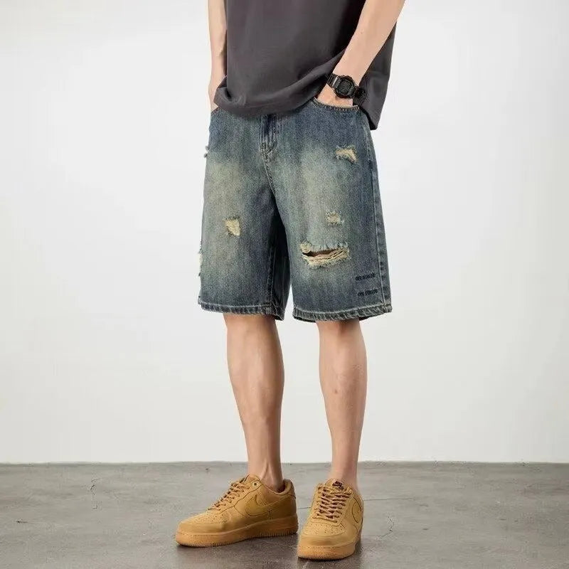 Men's blue denim shorts with retro loose hole distressing and a straight-leg cut.