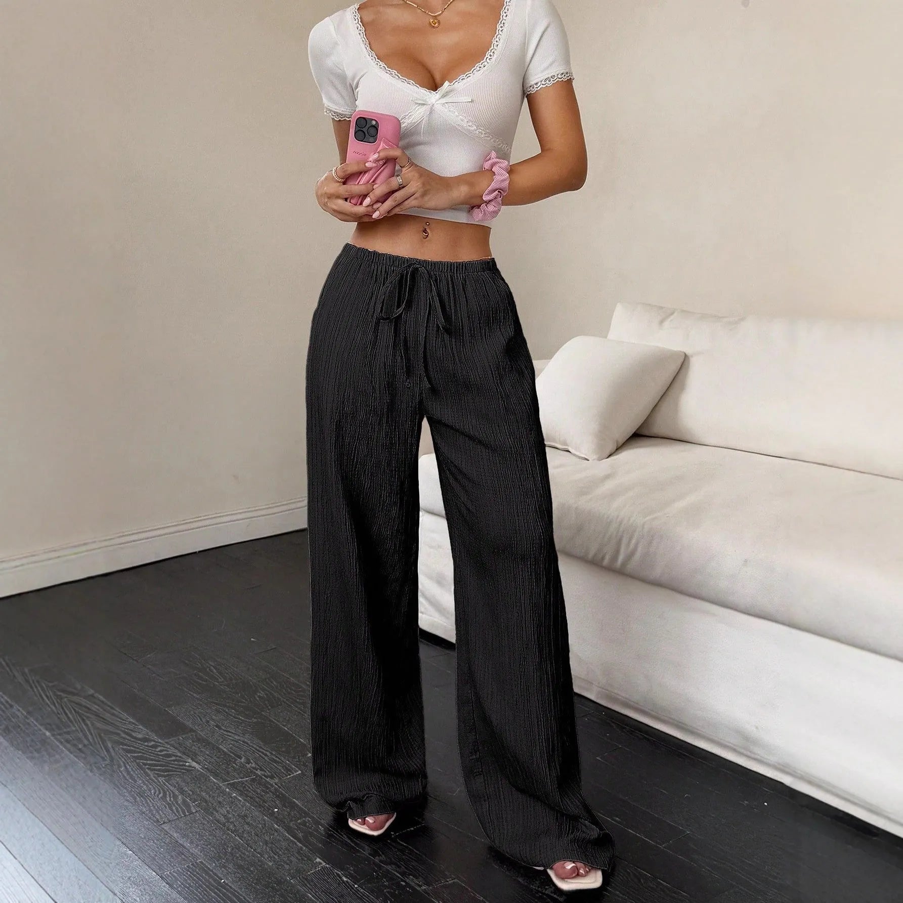 Women's black wide leg trousers with lace-up waist trimming detail showing mid-waist design