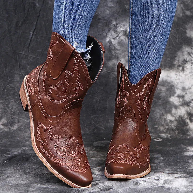 Women's blue cowboy boots with wedge heel, pointed toe, and embroidery details on low canister.