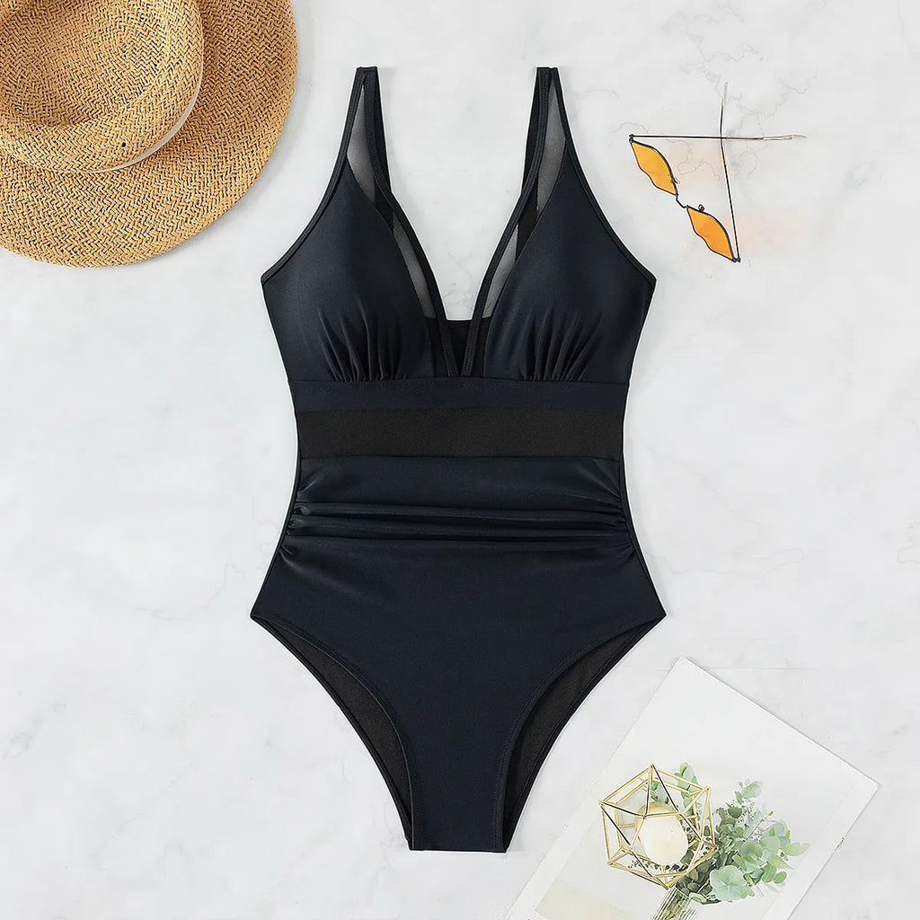 Black mesh halter bikini one-piece swimsuit on model showing sleeveless design and briefs style