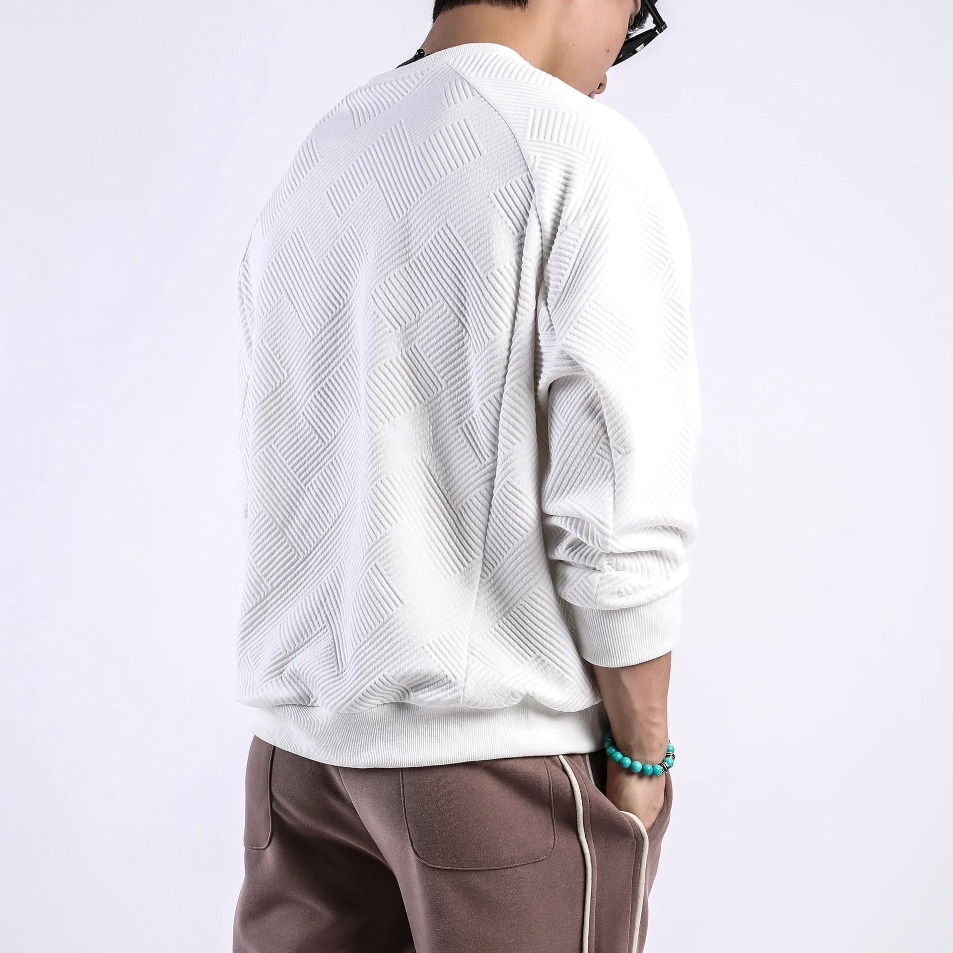 Men's solid colour twill jacquard long sleeve pullover sweater on a hanger.