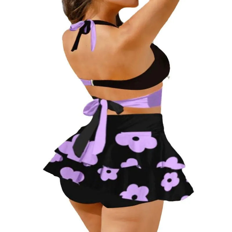Purple women's bikini with lace-up front and matching high-waisted split skirt.