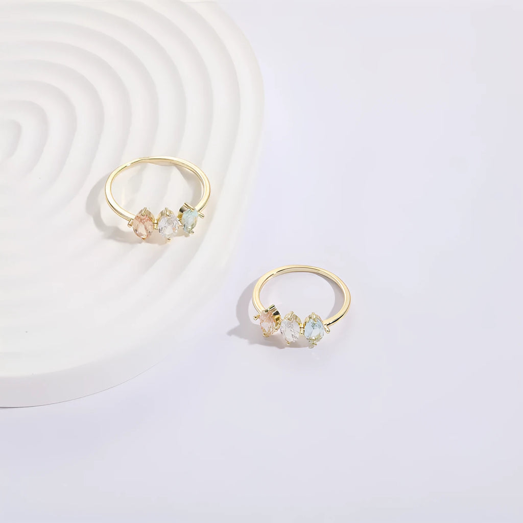 Geometric triangle birthstone ring with tricolour zircon and horse eye motif in gold plating.