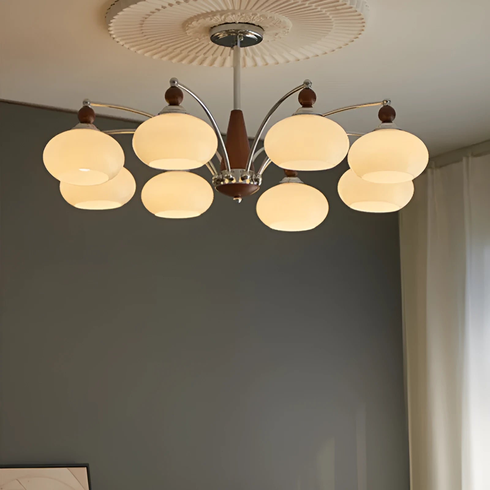 Middle Ancient style persimmon glass chandelier with chrome arms and milky white glass lampshades.