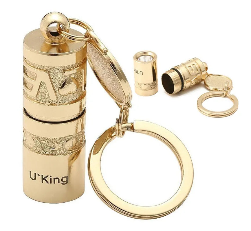 Gold-coloured waterproof mini LED keychain flashlight with zinc alloy housing on a key ring.