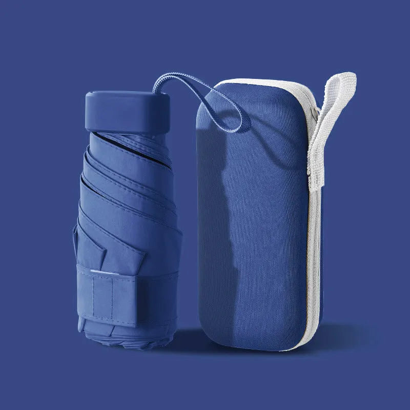 Six-fold manual umbrella in sky blue with capsule box storage, showing compact folded size and rubber handle