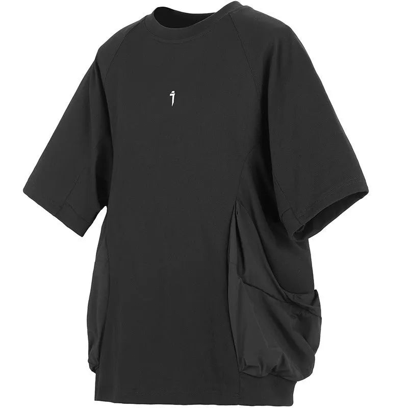 Man wearing a loose grey cotton T-shirt with large side pockets on a casual background.