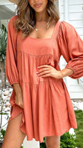 Orange red children's backless dress with a square collar and puff sleeves, showing A-line skirt and loose waist.