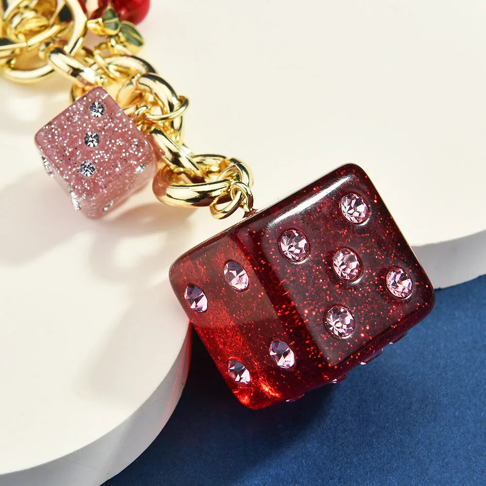 Square metal keychain pendant with cherry two-tone dice pattern and electroplated finish