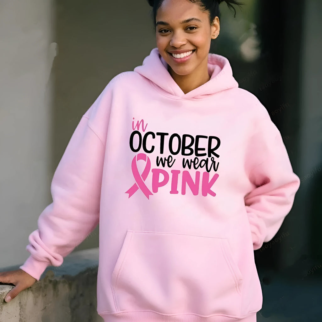 Women's pink pullover hoodie with 'In October We Wear Pink' and 'I'm A Survivor' retro hot stamping design and side seam pockets.