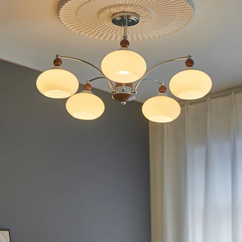 Middle Ancient style persimmon glass chandelier with chrome arms and milky white glass lampshades.