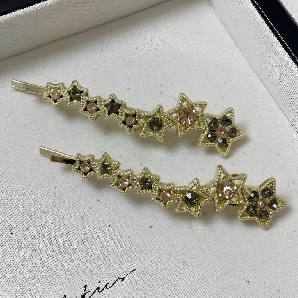 Golden alloy barrette hair clip with rhinestone star decoration and single-word element.