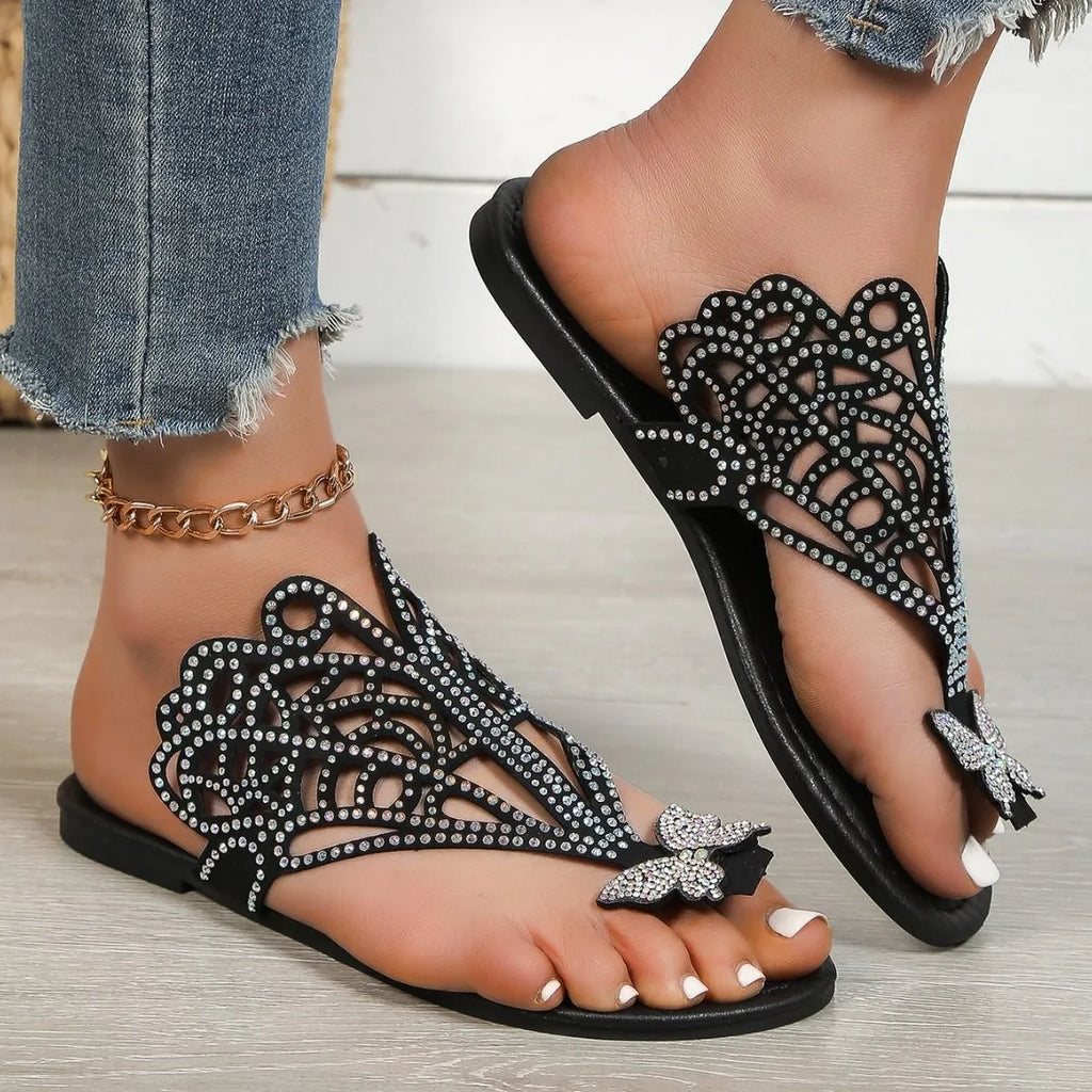 Women's black slip-on sandals with gold rhinestone decoration on the toe strap
