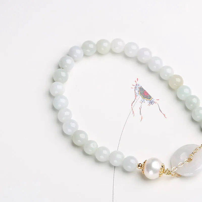 Natural emerald green jade round pendant on a women's bracelet with a geometric peace buckle.