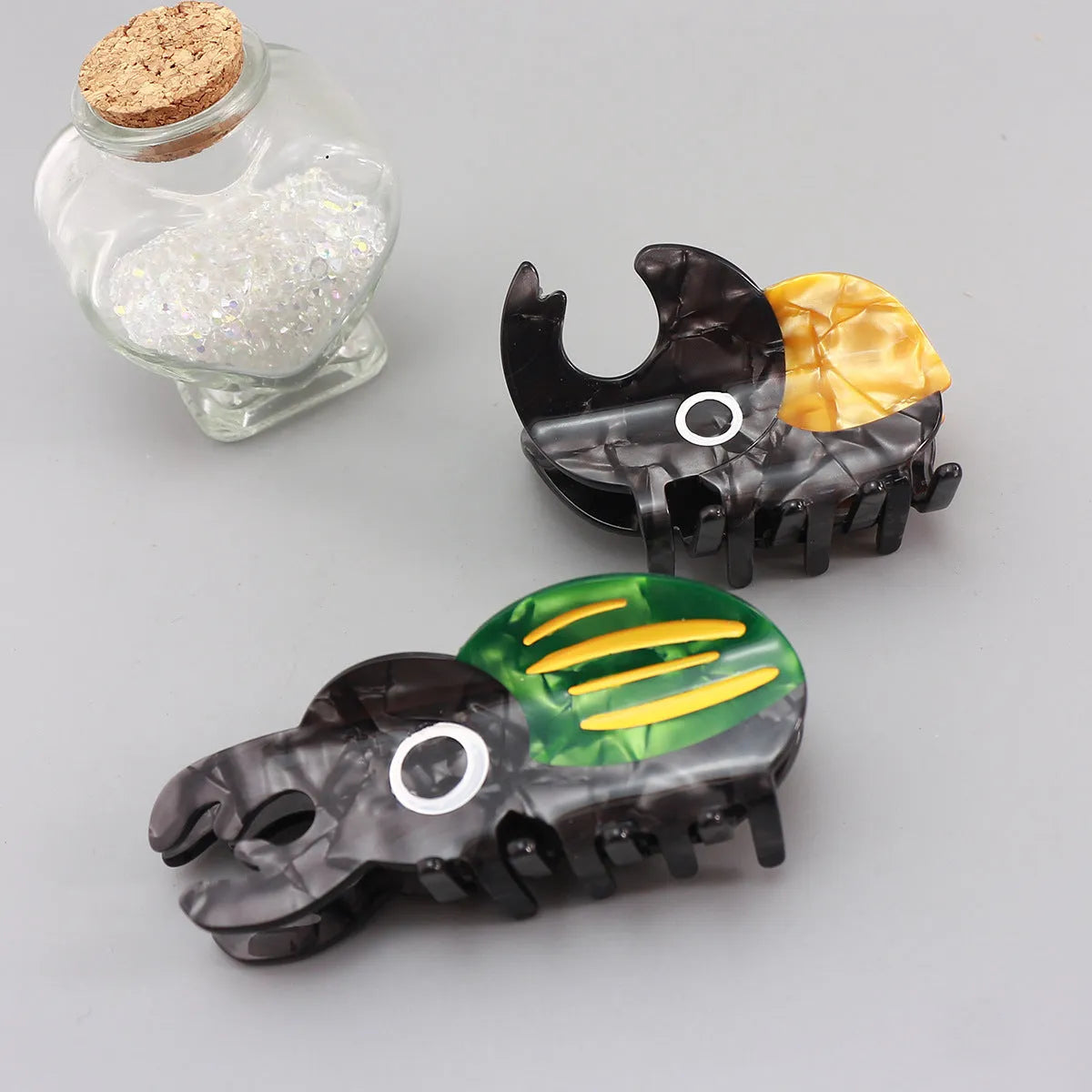Handmade green and orange beetle grip hair accessory with white cartoon caterpillar design