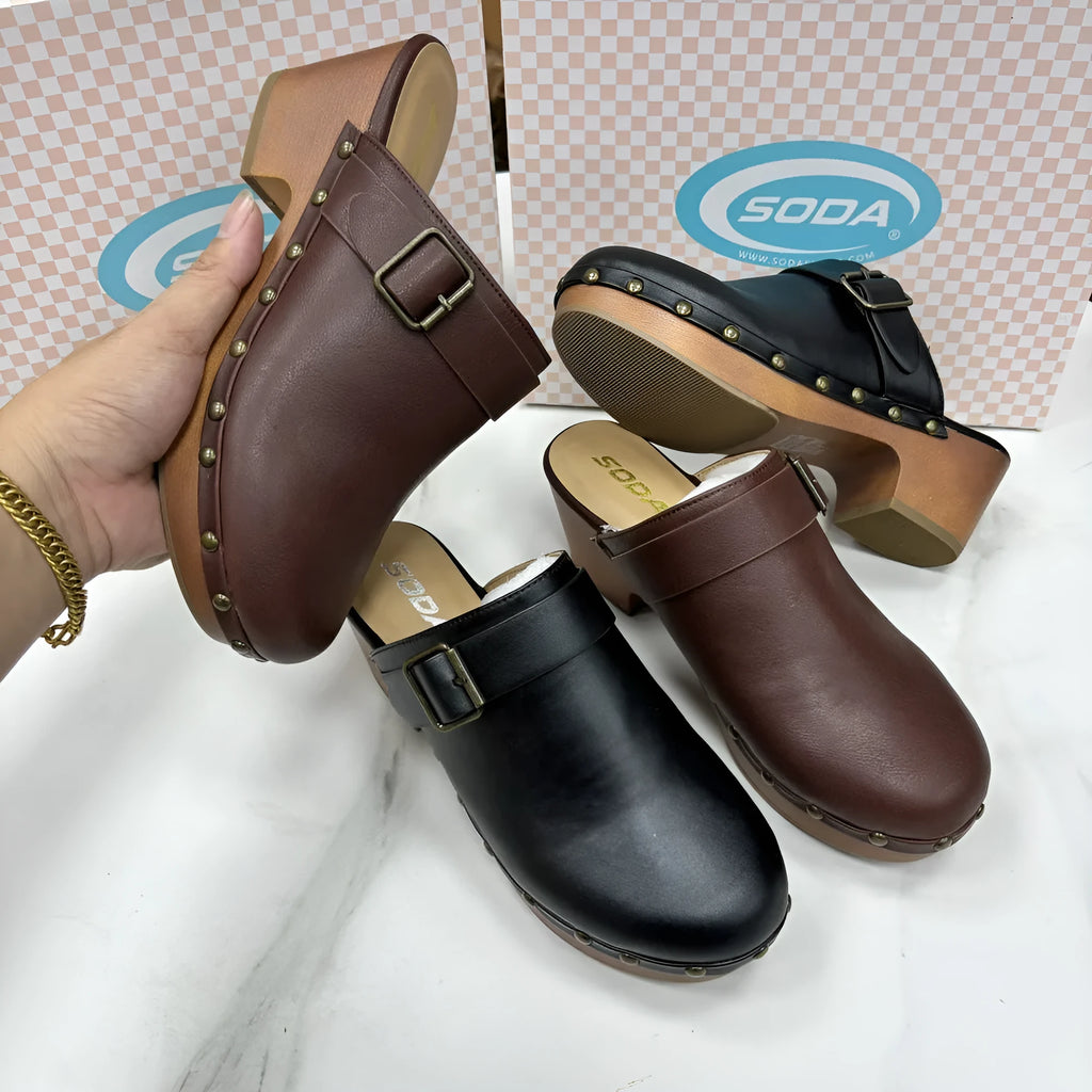Women's black chunky heel slippers with rivet details and closed toe on a rubber sole.