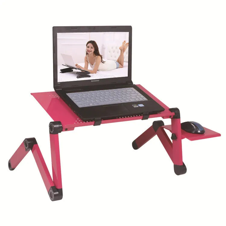 Red folding metal computer desk with extended legs and a mouse board, set up on a bed.