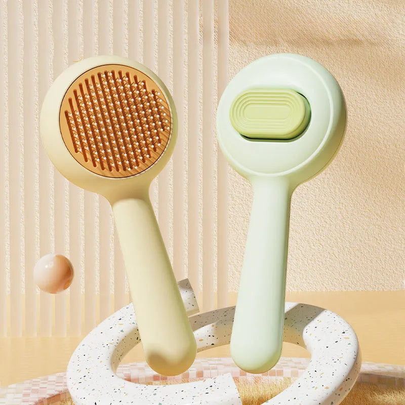 Green and yellow cat grooming brush with stainless steel comb and non-slip handle on a white background.