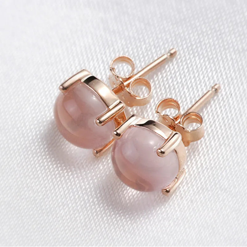 Rose gold coloured drop-shaped stud earrings with a synthetic ross quartz crystal inlay