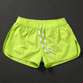 Men's loose orange polyester beach surfing trousers with elasticated fit on a size chart.