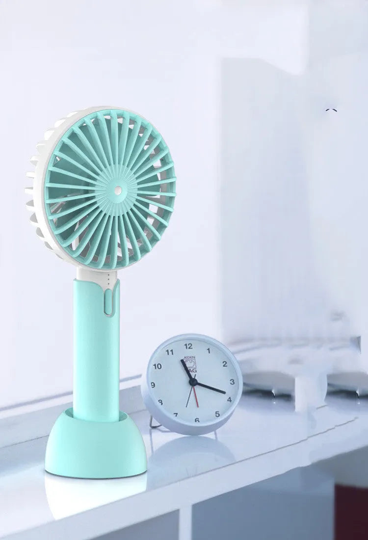 Blue handheld and desktop mini USB fan with oscillation function on a table.