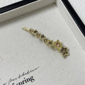 Golden alloy barrette hair clip with rhinestone star decoration and single-word element.