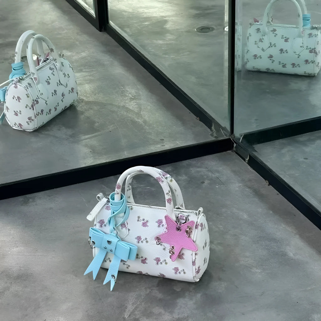White PU hand-held shoulder bag with petite floral bow accessory on display